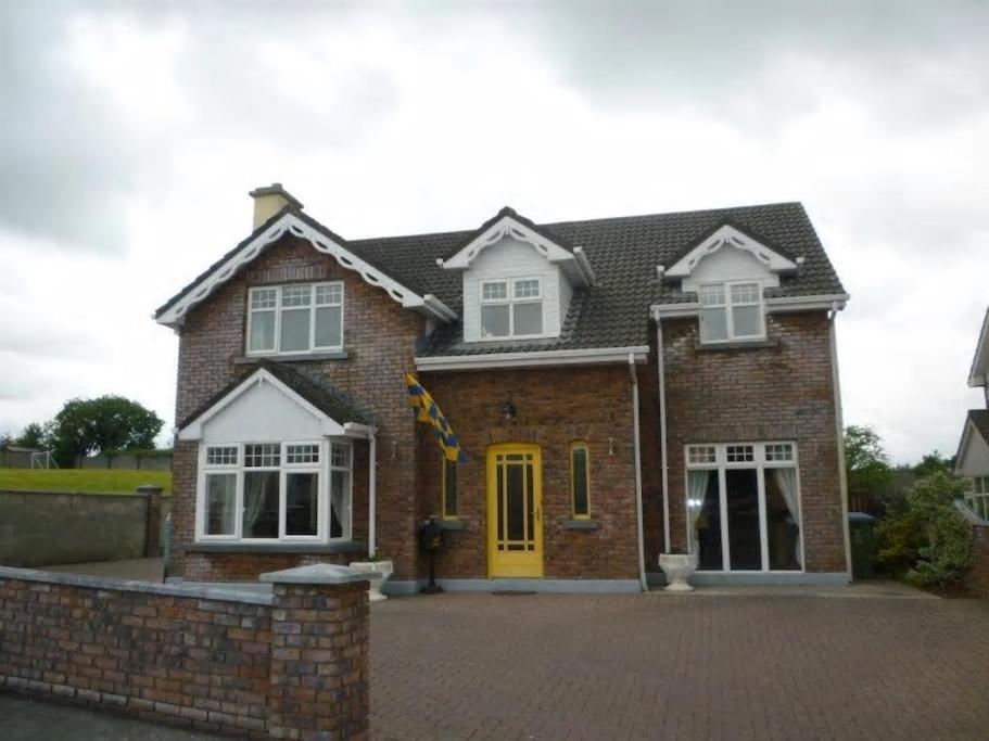 a brick house with a yellow door at Fealys in Ennis