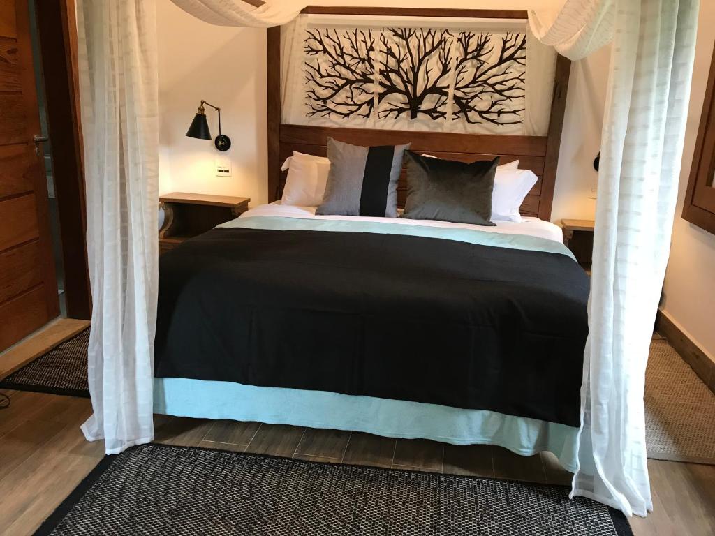 a bedroom with a bed with a black comforter at Chalé Realli in Visconde De Maua
