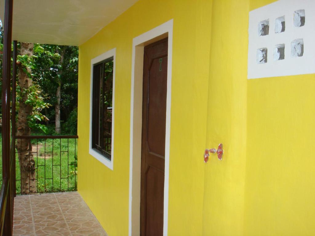 a room with a yellow wall and a door at RCJ Pension House in Estancia