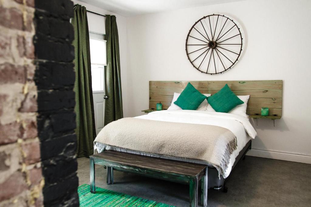 een slaapkamer met een bed en een klok aan de muur bij L'Hotel Particulier Griffintown in Montreal