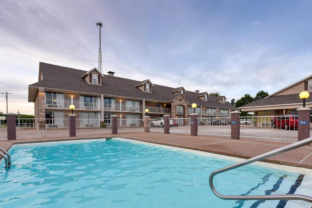 a large swimming pool in front of a building at Interstate Inn in Roland