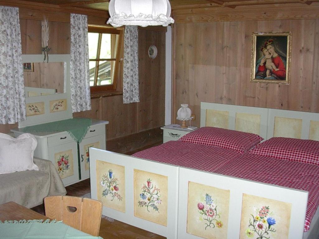 una camera da letto con un grande letto con lenzuola rosse di Malernhof a Kitzbühel