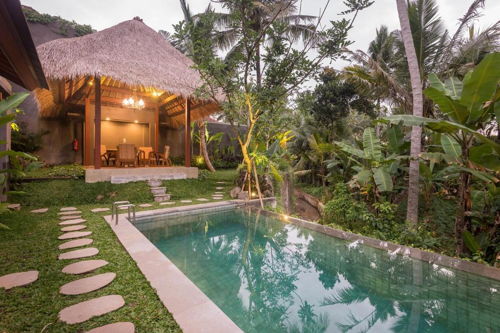 a villa with a swimming pool and a house at ILA Villa Ubud in Ubud