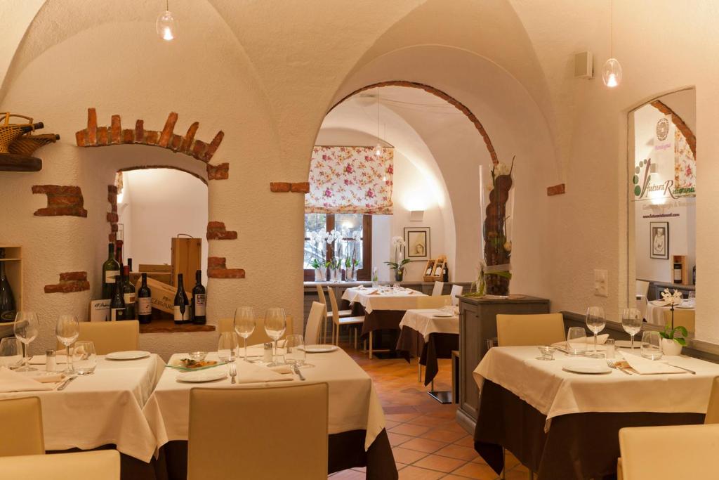 un ristorante con tavoli con tovaglie bianche di Albergo Ristorante La Palma a Bissone