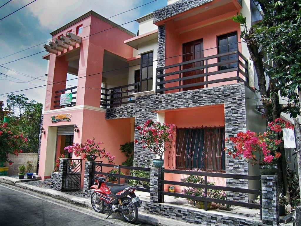 uma moto estacionada em frente a um edifício cor-de-rosa em R&E Bed & Breakfast em Ivana