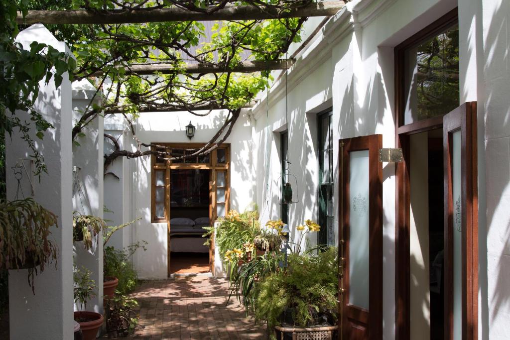 un callejón en un edificio blanco con plantas en 22 Van Wijk Street Tourist Accommodation en Franschhoek