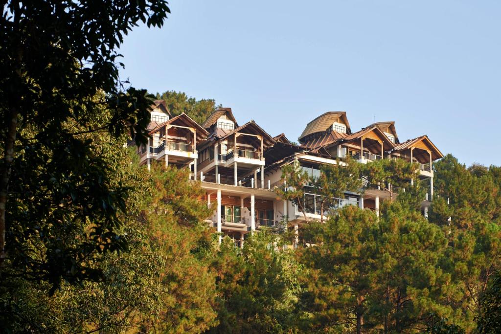 a large building on top of a hill with trees at Ri Kynjai Serenity by The Lake in Shillong