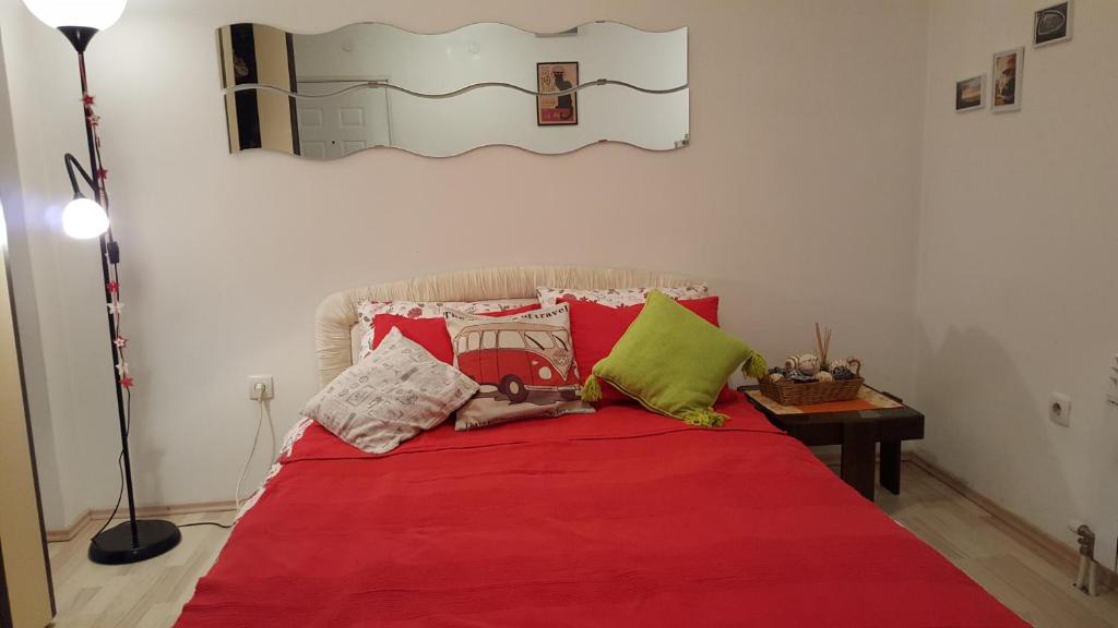 a bed with a red blanket and pillows on it at Apartment Greenfield in Belgrade