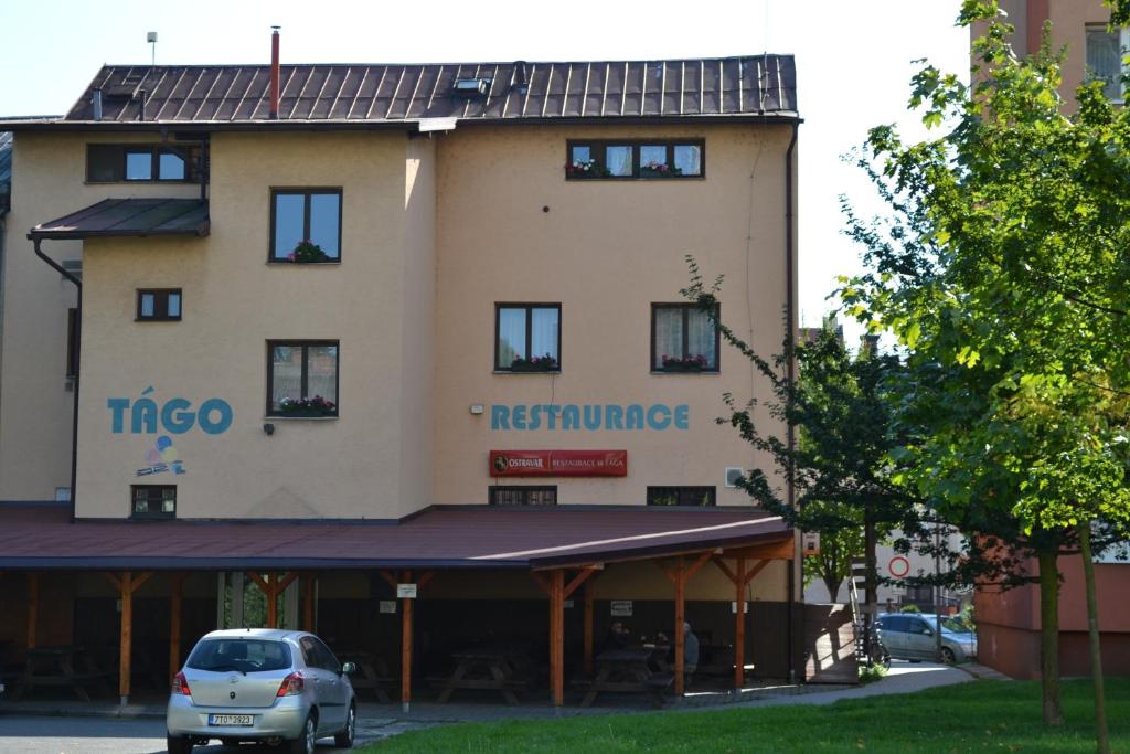 a building with a car parked in front of it at Penzion Tágo Bohumín in Bohumín