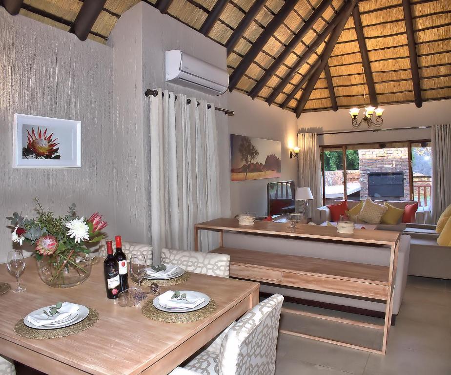 a living room with a table with wine bottles on it at Kruger Park Lodge Unit No. 509 in Hazyview