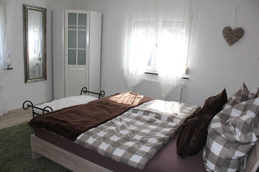 エメンディンゲンにあるAppartement am Elzdammのベッドルーム1室(チェック入りの毛布付きのベッド1台付)