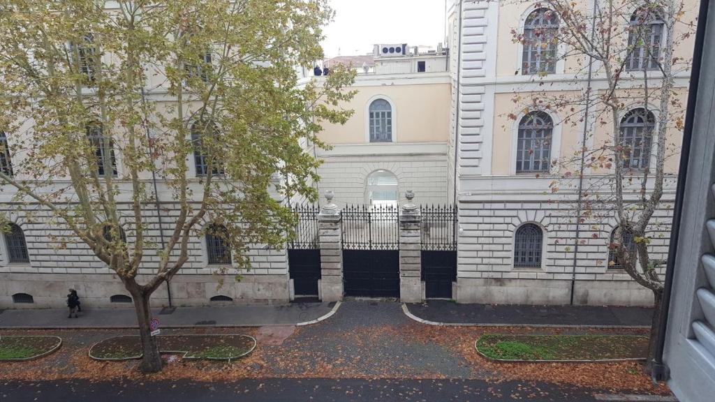 un edificio con un recinto e un albero di fronte ad esso di tagliaferri lucia a Roma