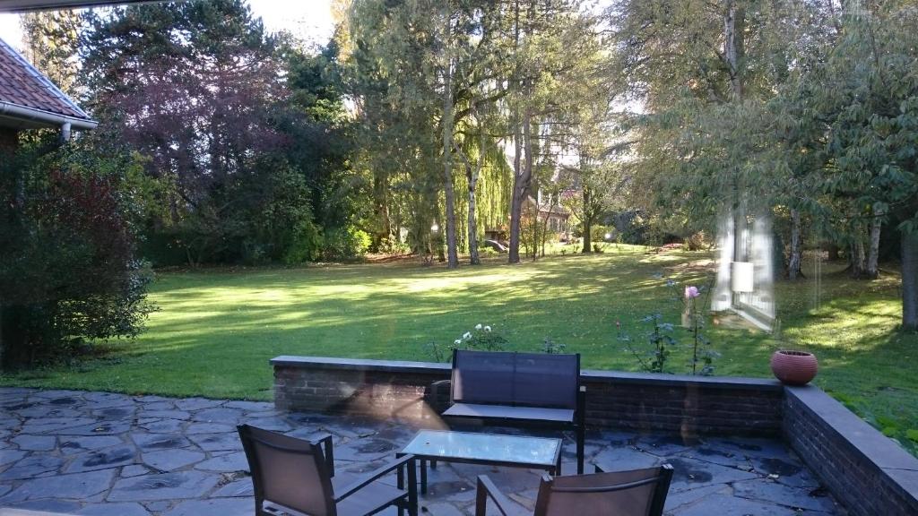 d'une terrasse avec une table et des chaises dans la cour. dans l'établissement La belle Monsoise, à Mons-en-Baroeul