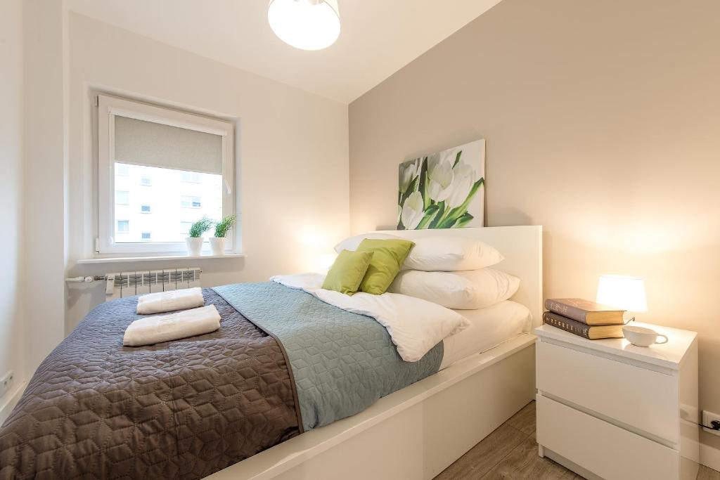 ワルシャワにあるP&O Apartments Okecieのベッドルーム1室(枕付きのベッド1台、窓付)