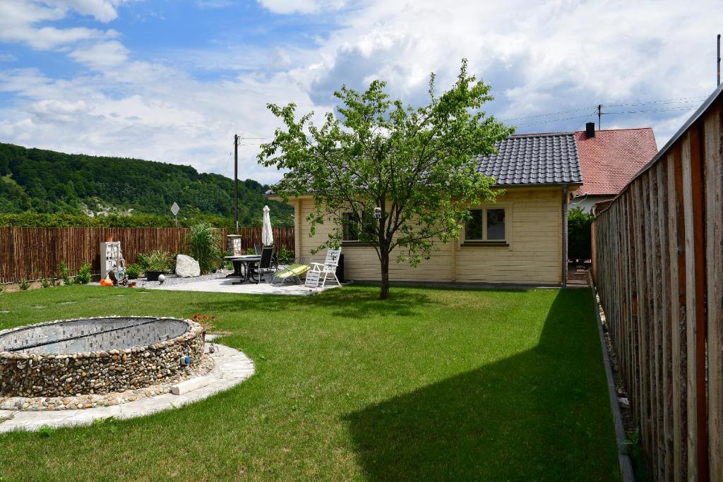 einen Hof mit einem Haus mit einem Baum und einem Zaun in der Unterkunft Ferienhaus Holzhaisl in Kelheim