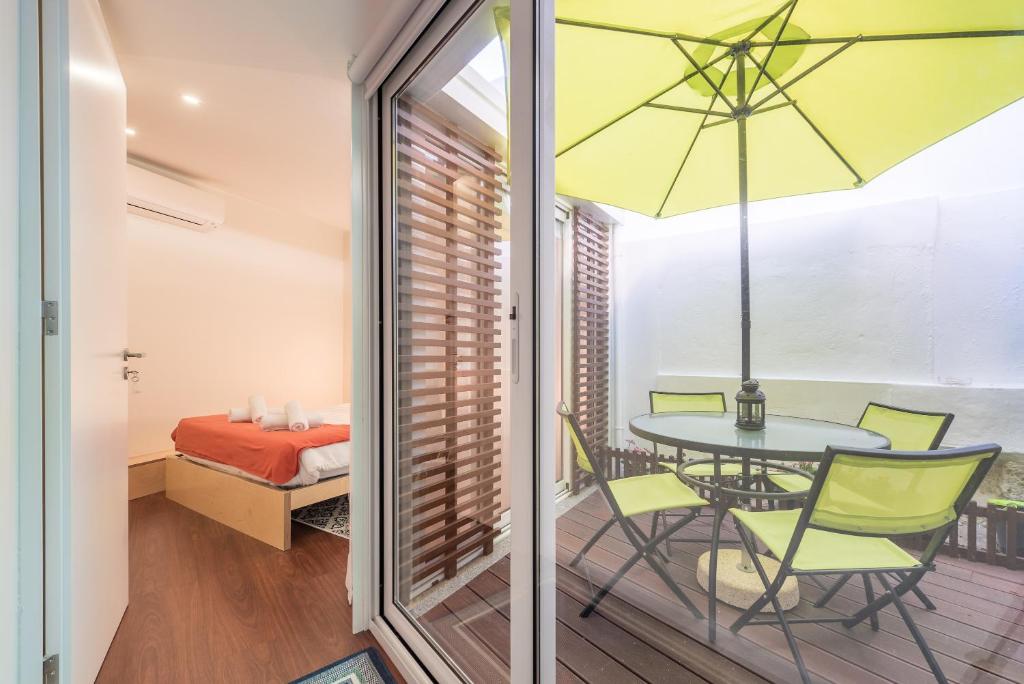 een kamer met een tafel en stoelen en een slaapkamer bij Beloved in Porto