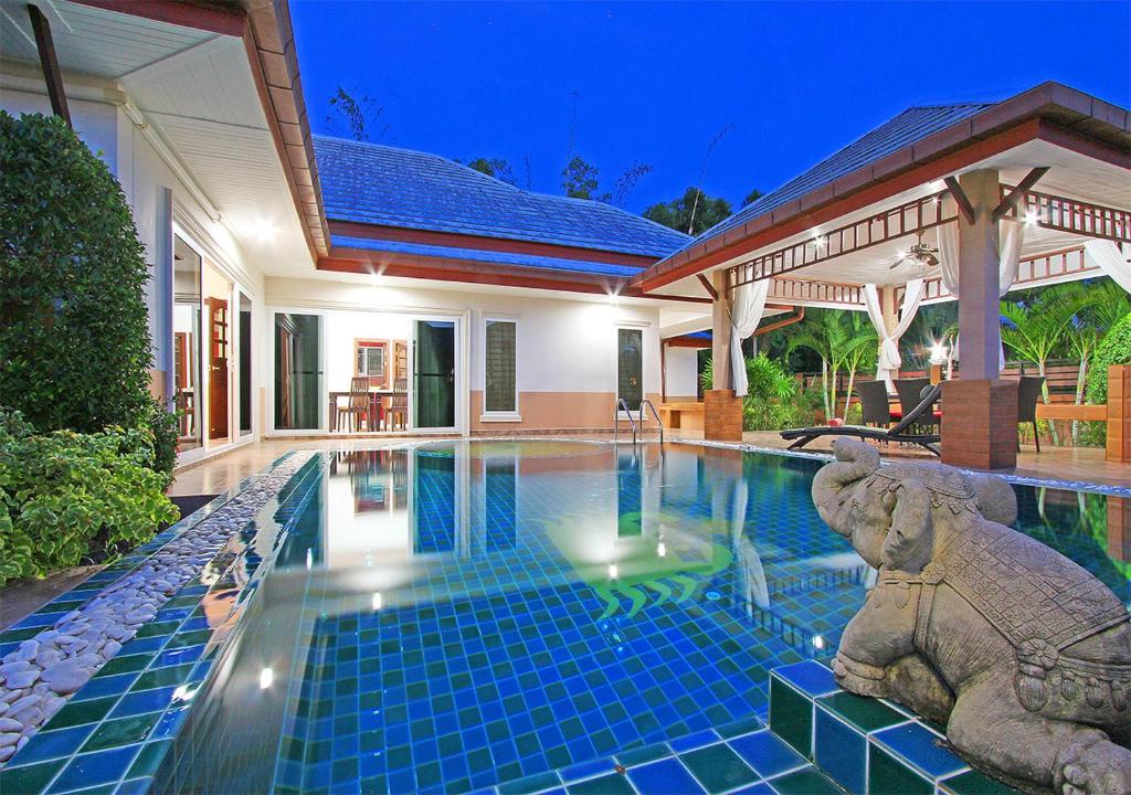 uma casa com piscina em frente a uma casa em Victoria Villa Vintc 3 em Na Jomtien