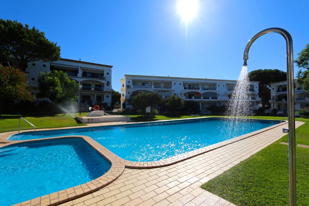 una piscina con una fuente frente a un edificio en Pinhal do Golf - Clever Details, en Vilamoura