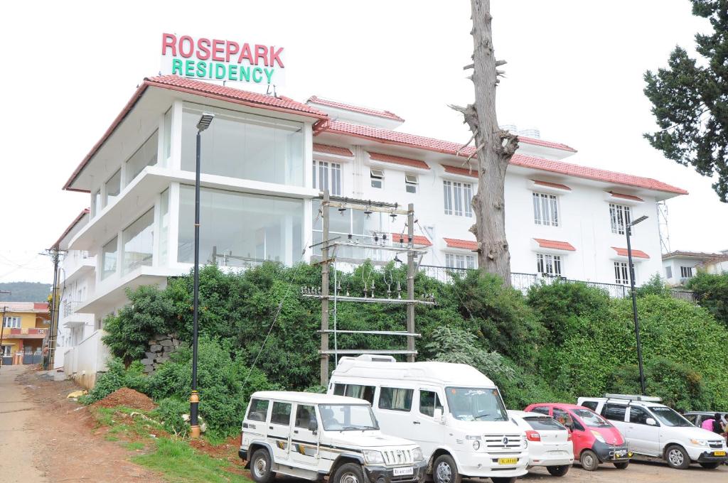 een witte truck geparkeerd voor een gebouw bij Rosepark Residency in Ooty