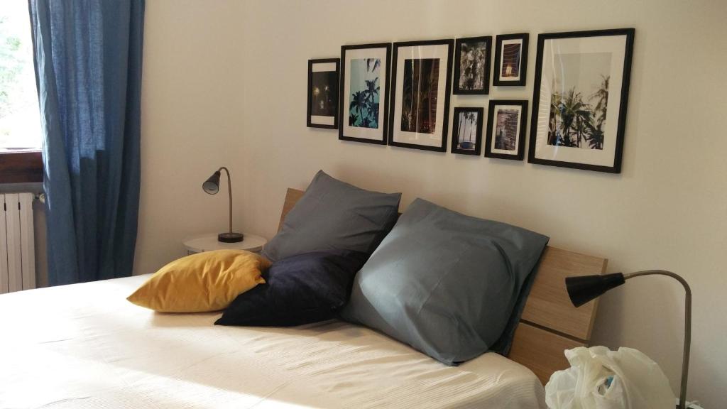 - une chambre dotée d'un lit avec des oreillers et des photos sur le mur dans l'établissement Bianca Studio, à Guanzate