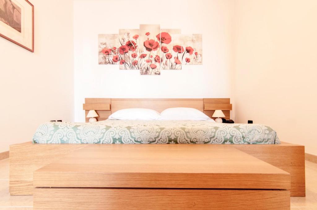 a bed with a wooden headboard in a bedroom at Ciao Hotel & Residence in Conversano