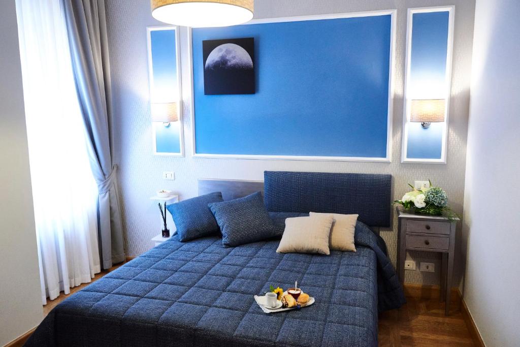 una camera con un letto blu e un vassoio di Domus Cavour Guest house a Roma