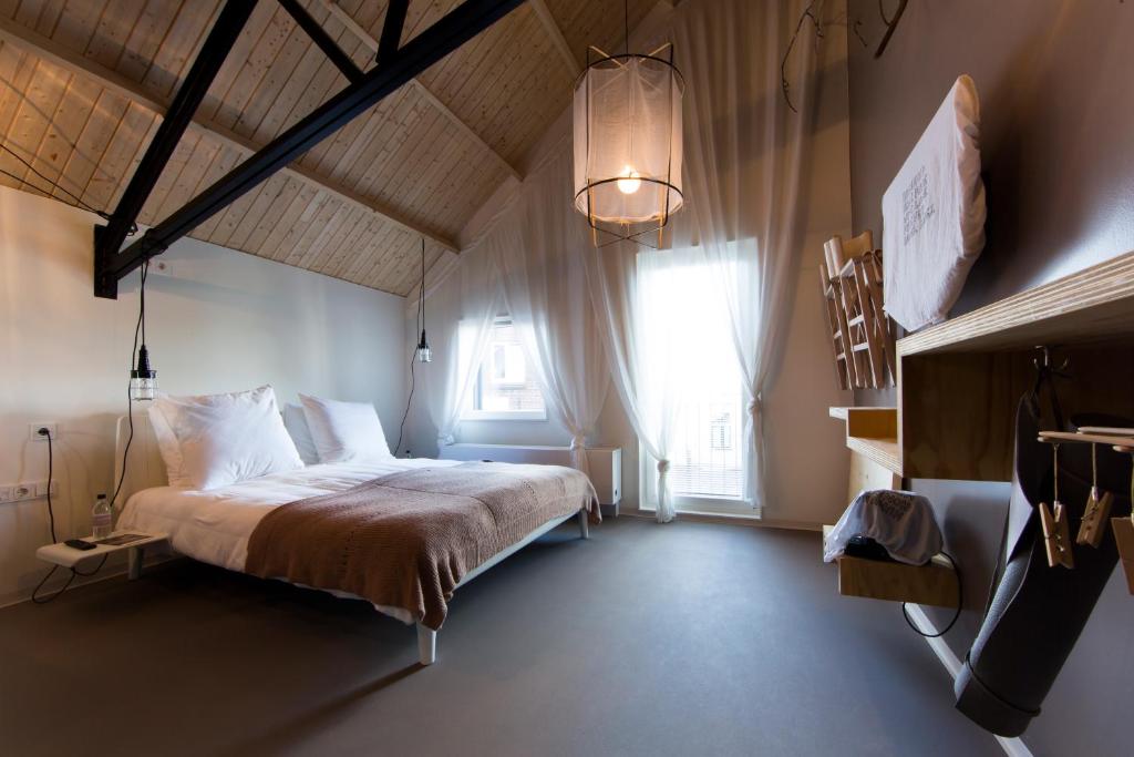 een slaapkamer met een bed en een groot raam bij Design Hotel Modez in Arnhem