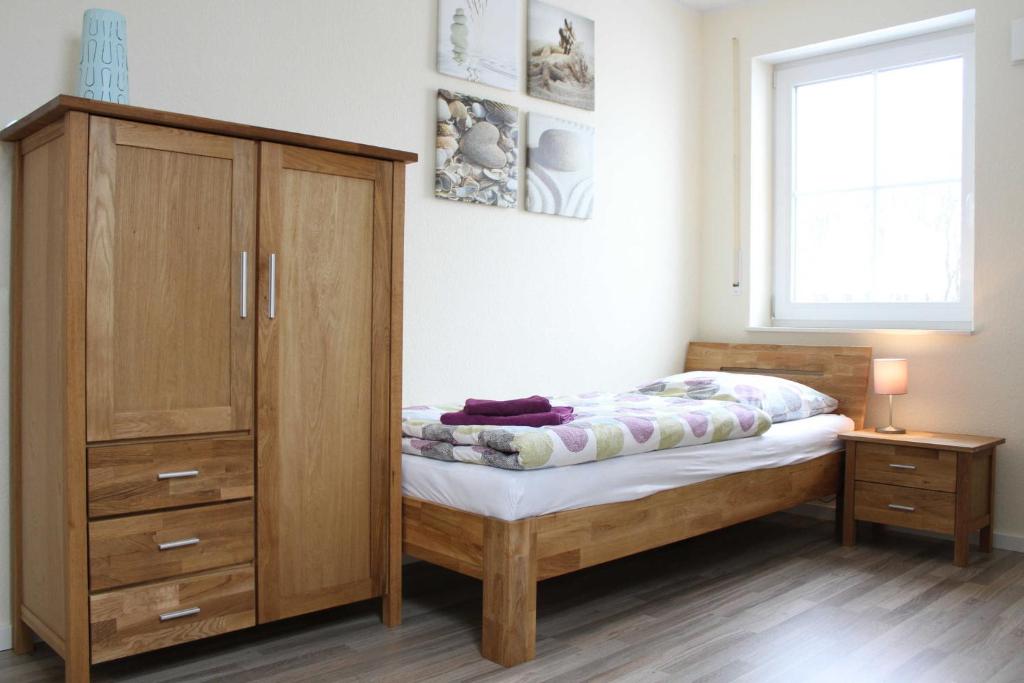 ガルレルにあるFerienhaus Seesternのベッドルーム1室(ベッド1台付)、木製キャビネットが備わります。