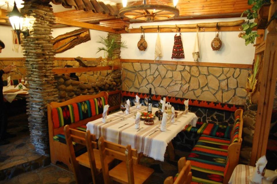 un comedor con mesa y sillas en un restaurante en Balkanski chanove, en Botevgrad