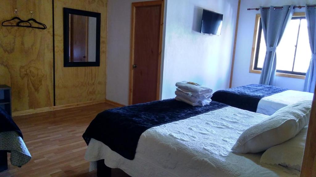 a hotel room with two beds and a tv at Residencial del Maule in Linares