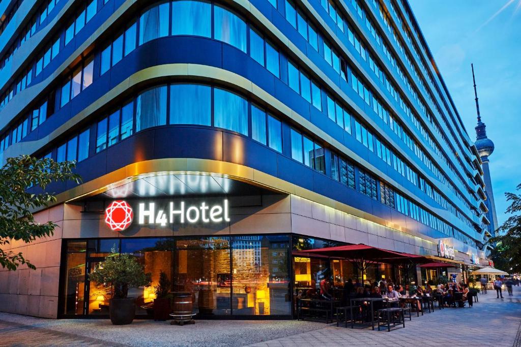 un grand bâtiment avec un panneau d'hôtel dans l'établissement H4 Hotel Berlin Alexanderplatz, à Berlin