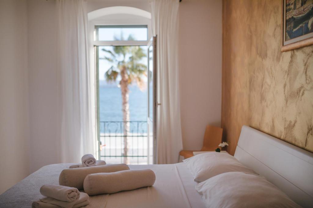 斯普利特的住宿－奧巴拉特魯姆比卡海景公寓，一间卧室配有一张带毛巾的床,设有窗户