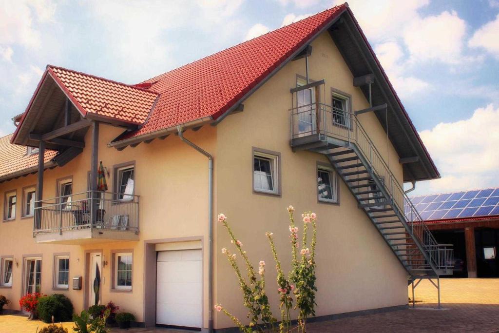 a house with a red roof and a garage at Ferienwohnung Ernle in Bad Wurzach