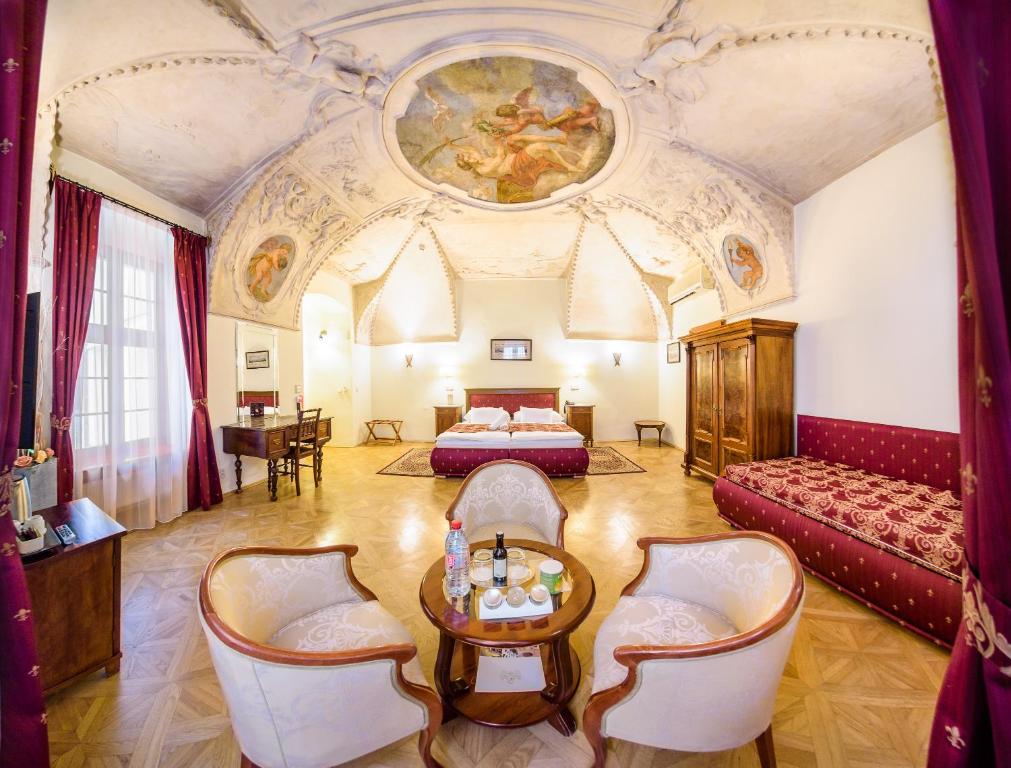 a large room with a bed and a table and chairs at Hotel Elite Prague in Prague