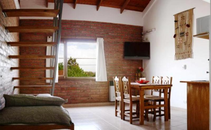 a kitchen and dining room with a table and chairs at Rincon Gales in Puerto Madryn