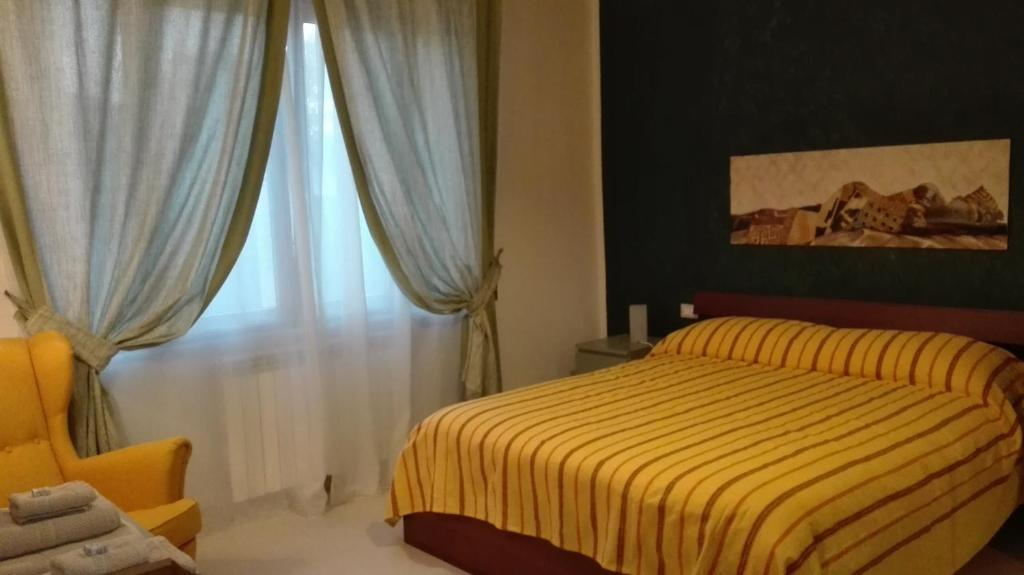Un dormitorio con una cama amarilla y una ventana en Casa Millegrü, en Pisa