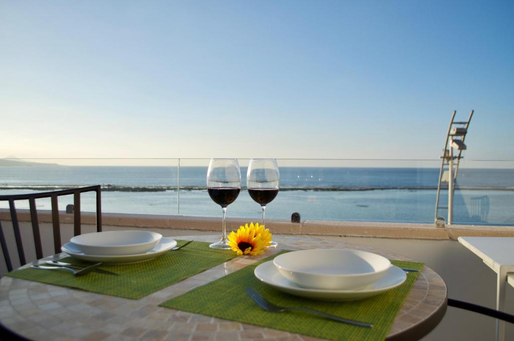 un tavolo con due bicchieri di vino e una vista sull'oceano di La Grand Suite Las Canteras a Las Palmas de Gran Canaria