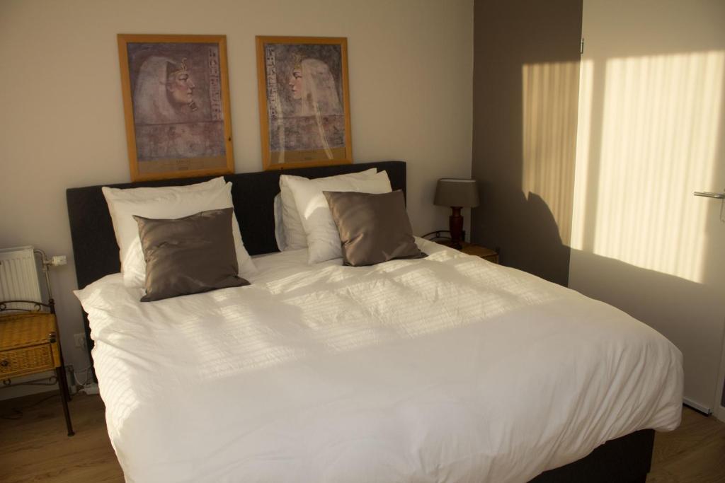 a bedroom with a large white bed with two pillows at Marbles Inn in Amsterdam