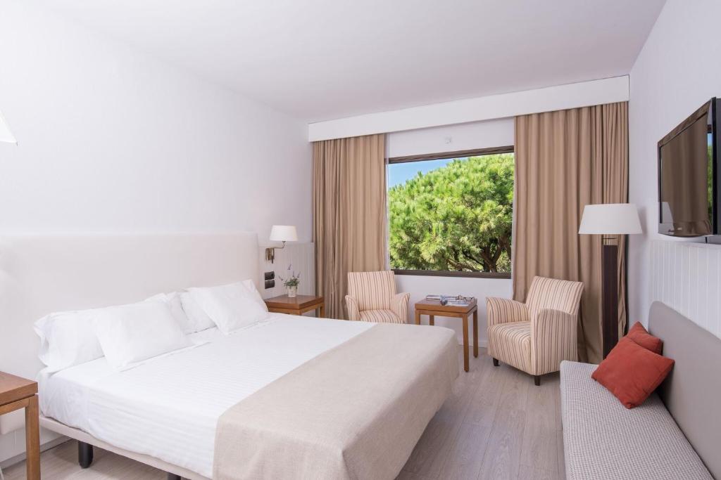 a hotel room with a bed and a large window at La Costa Hotel Golf & Beach Resort in Pals
