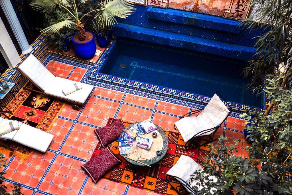 widok na basen z krzesłami i stołem w obiekcie Riad 58 Blu w Marakeszu