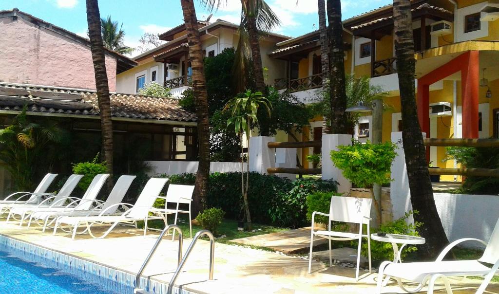 a group of chairs sitting next to a swimming pool at Pousada Vento Norte in Ilhabela