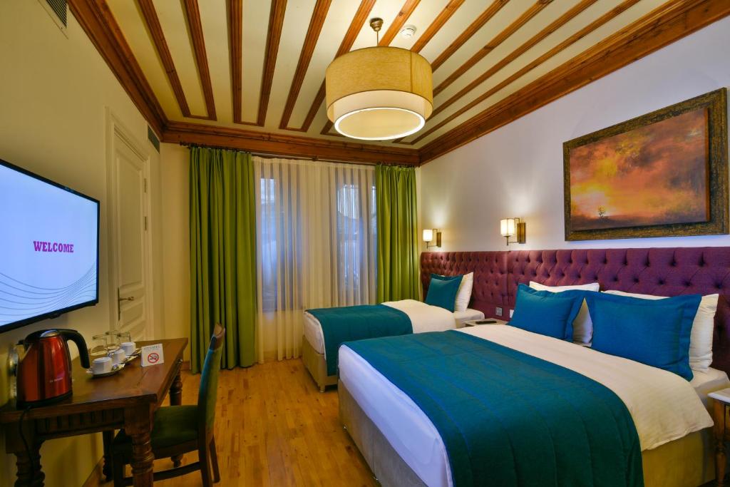 a hotel room with two beds and a flat screen tv at Istanbul Life Hotel in Istanbul