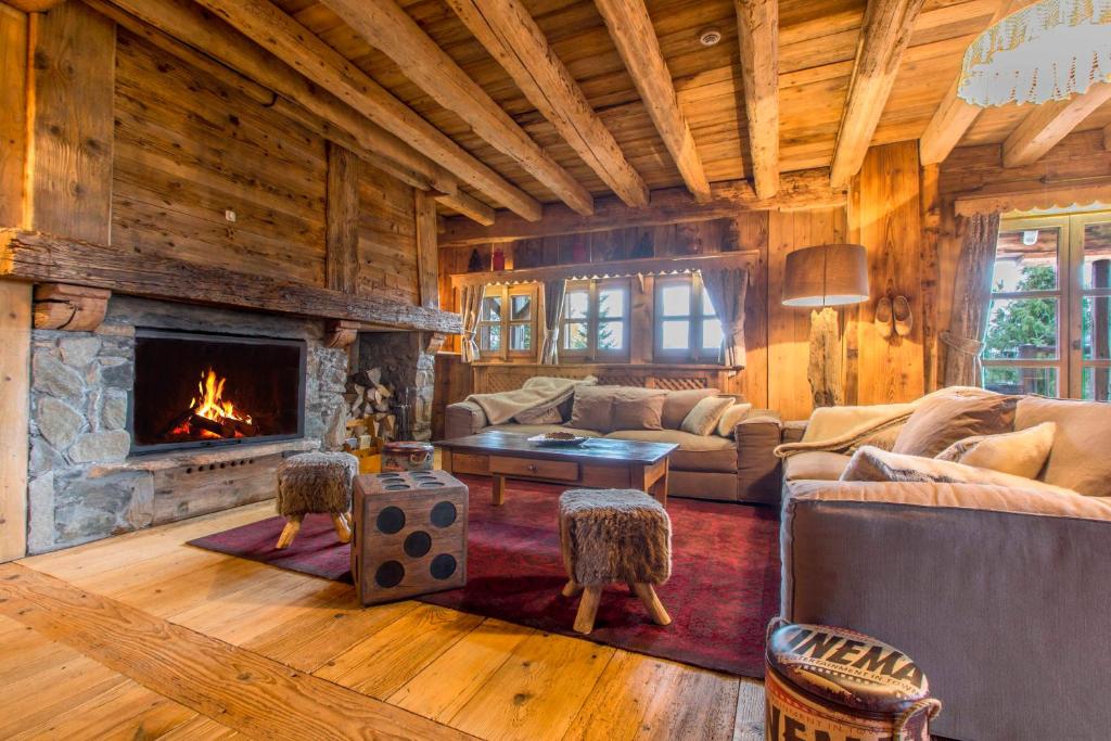 a living room with a fireplace in a log cabin at Chalet Persan in Megève