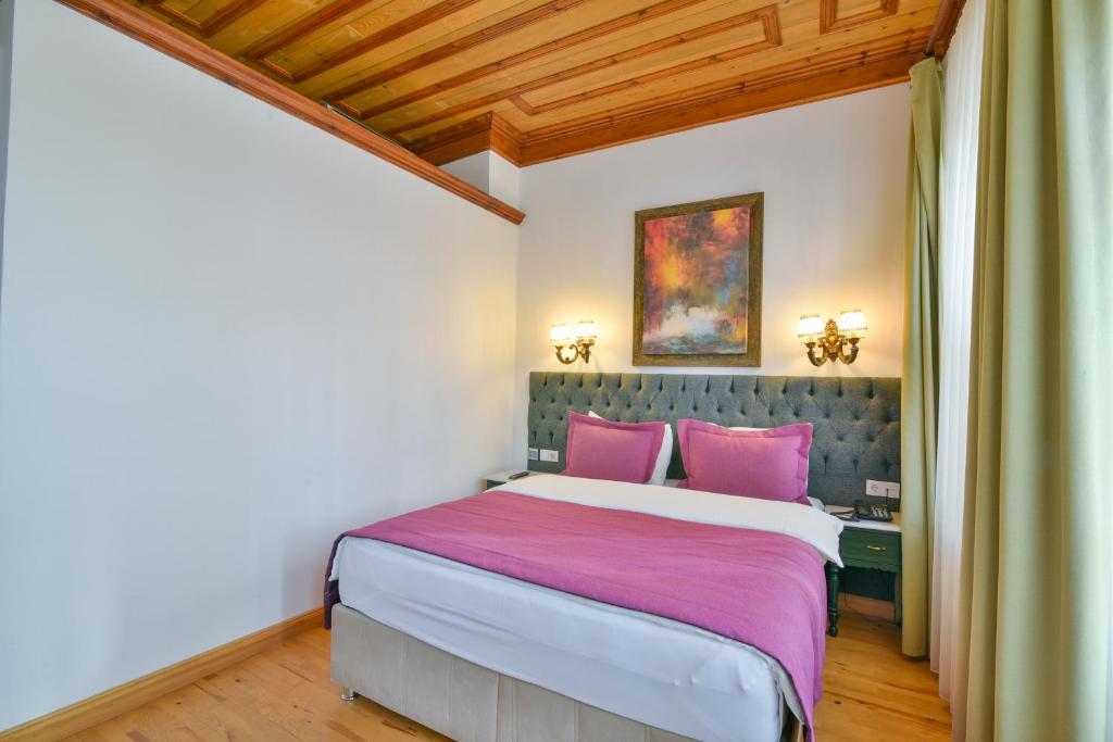a bedroom with a large bed with pink pillows at Istanbul Life Hotel in Istanbul