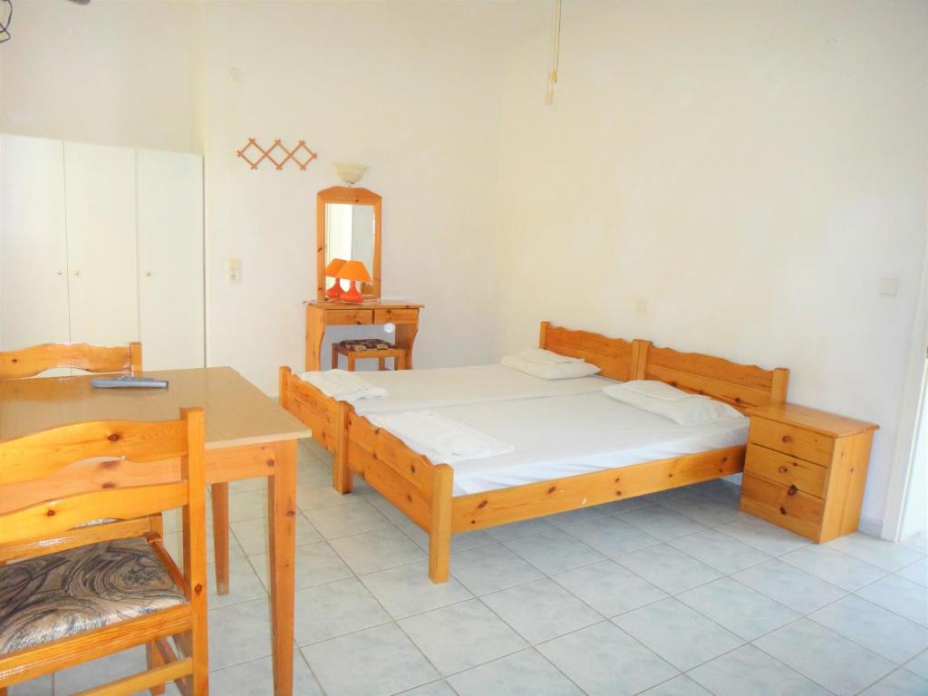 a bedroom with two beds and a table and a mirror at Pagona Hotel in Loutra Edipsou