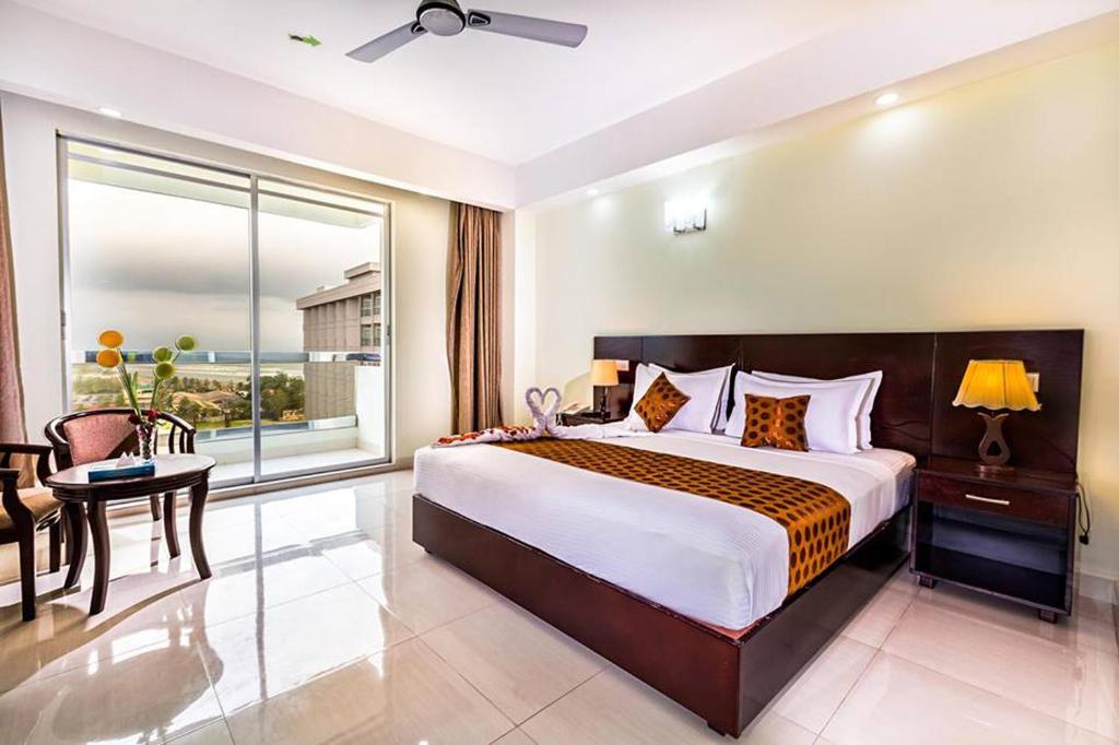a bedroom with a large bed and a large window at Hotel Sea Uttara in Cox's Bazar