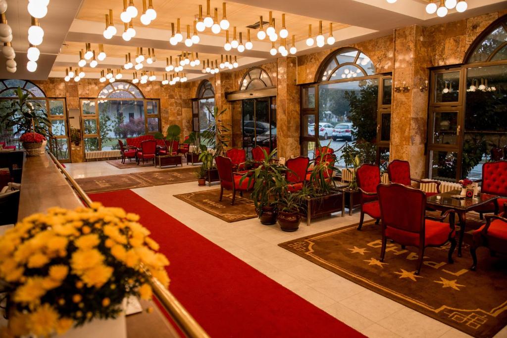 a restaurant with red chairs and a red carpet at Hotel Grand in Valjevo