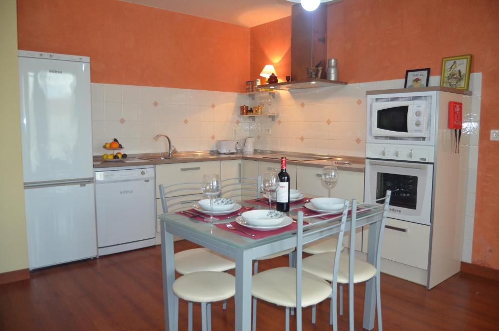 una cocina con mesa con sillas y una botella de vino en Casa Emma, en Villamarciel