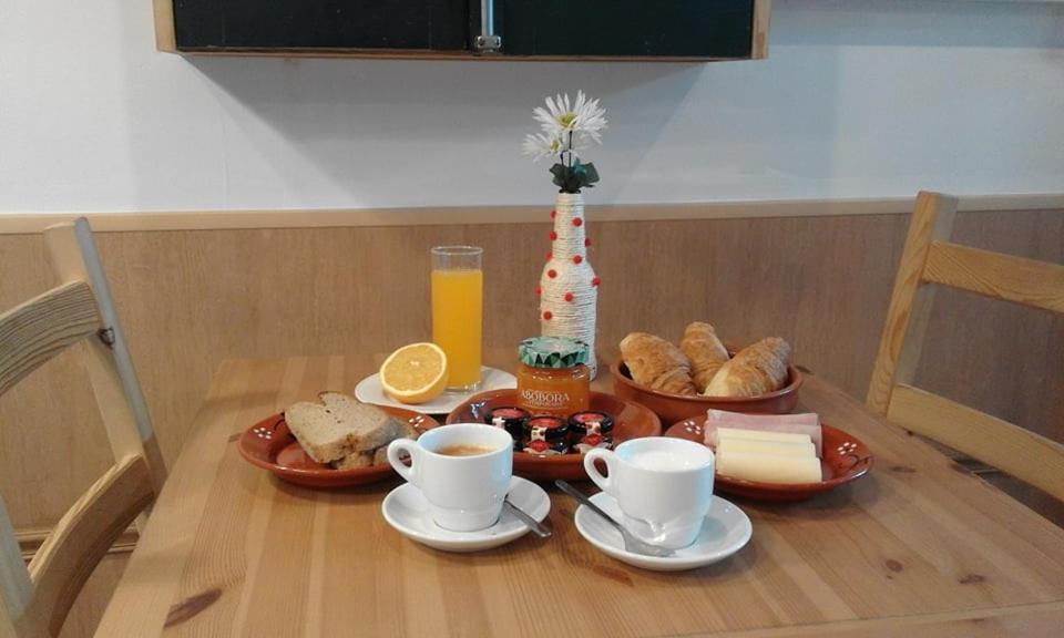 a table with cups of coffee and pastries on it at Zurstrassen Apartment in Coimbra