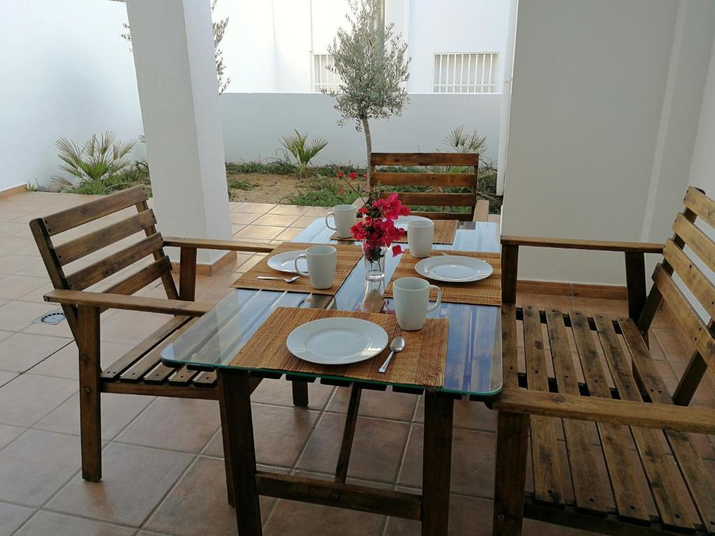 ラス・ネグラスにあるApartamento Los Olivosの木製テーブルと椅子(皿、花付)